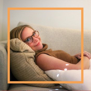 a photo of Natasha reclined on the couch, smiling at the camera