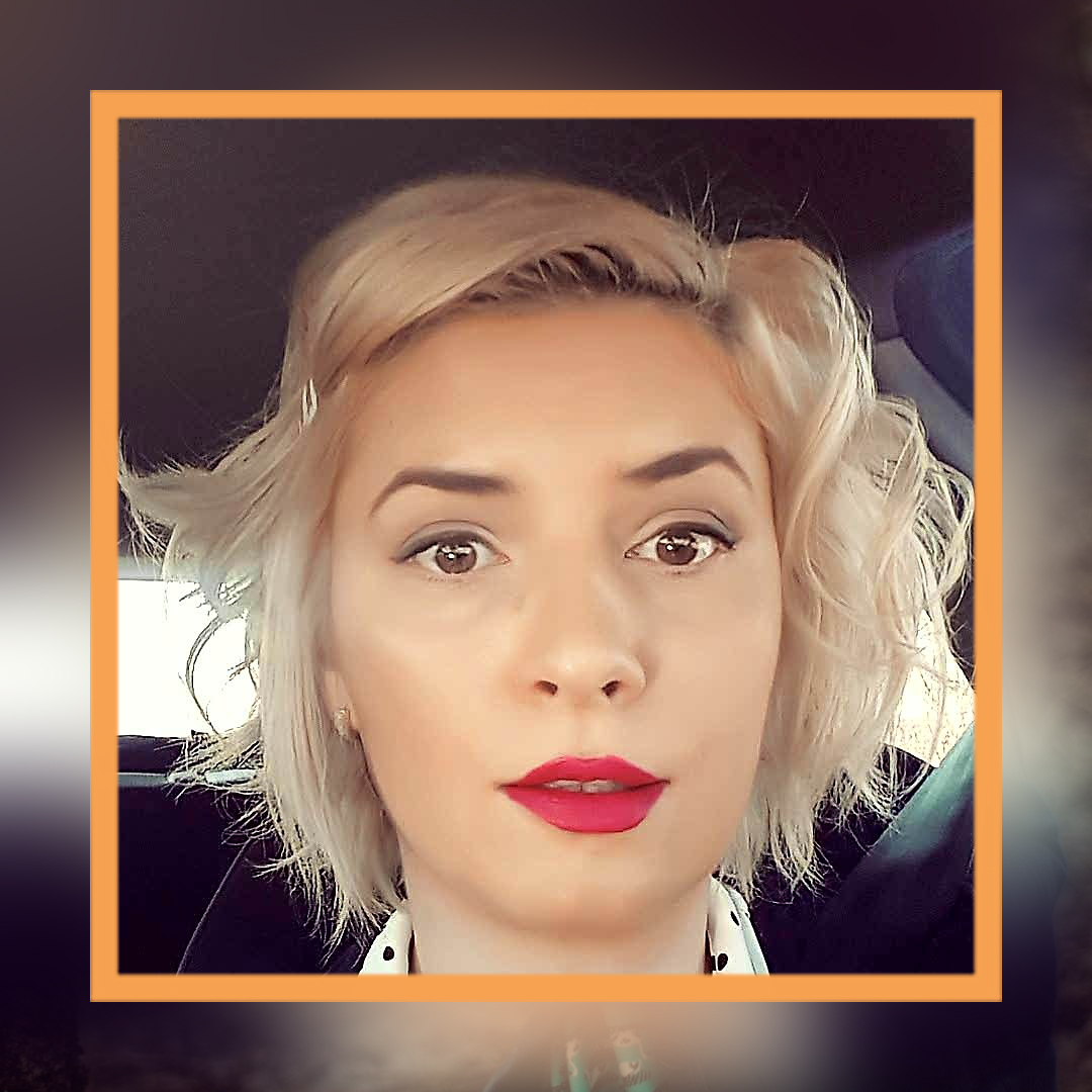 A photo of Ruxandra's face.She has curly blonde bobbed hair and wears bright red lipstick.