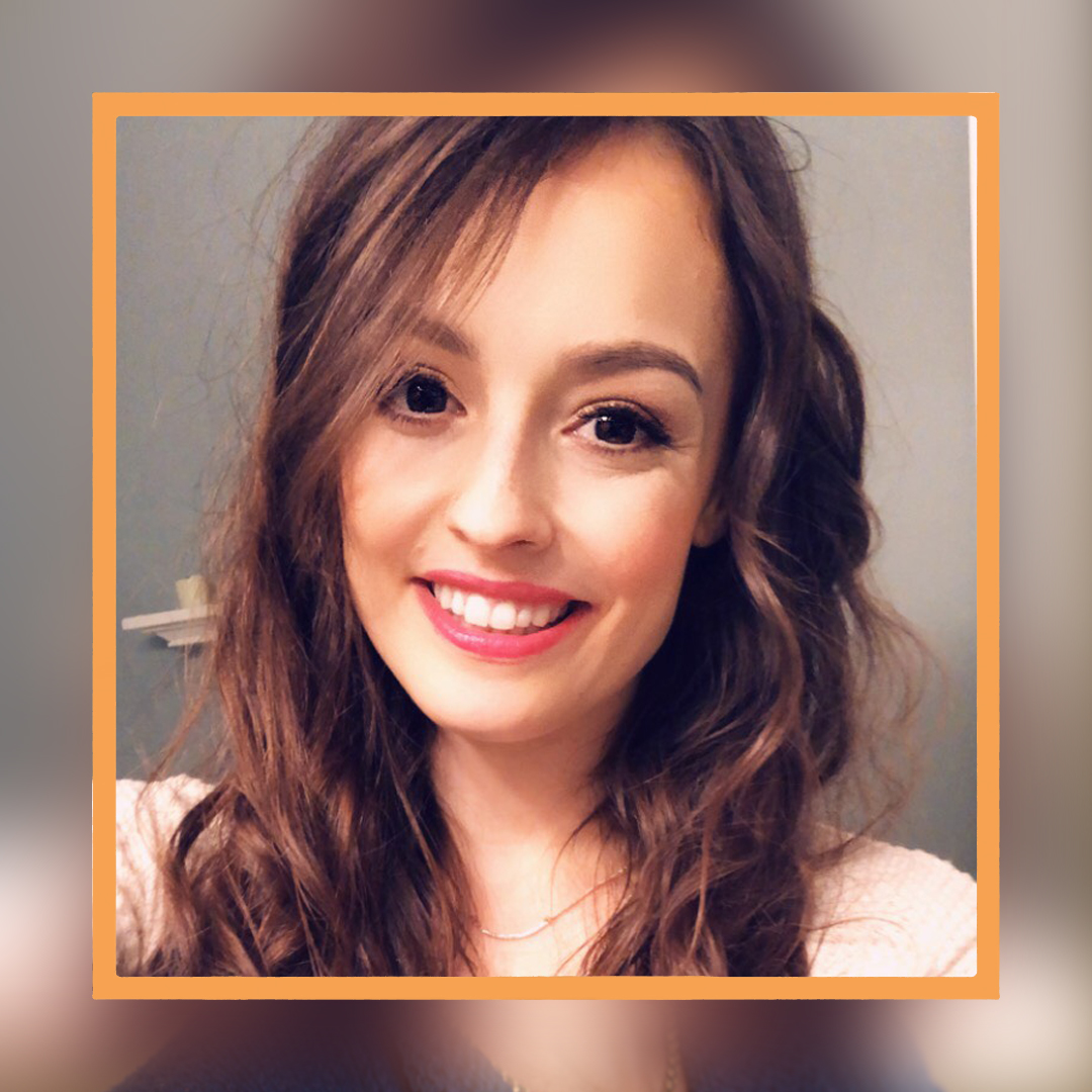 Emily, a white woman with long wavy brown hair, smiles at the camera. There is an orange square superimposed around her face.