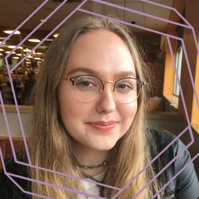 Mahalah, a white woman in her early 20s with long blonde hair and thin wire-framed glasses, smiles at the camera. There is a stylized purple hexagon framing the photo