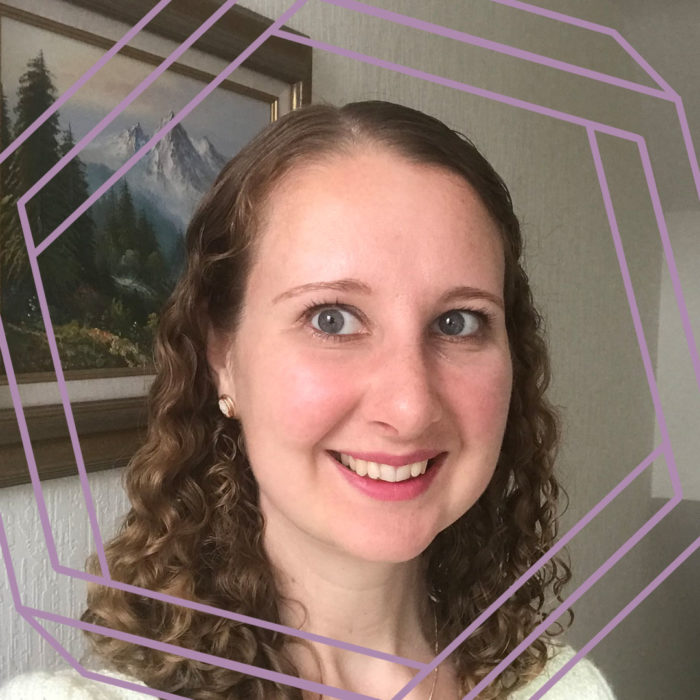 Christie, a white woman with curly shoulder-length brown hair, smiles at the camera. There is a stylized purple hexagon framing the photo.